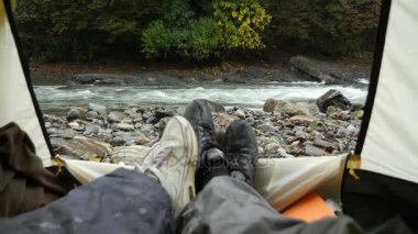 4 k. görünümünden bir turist çadır bir dağ nehir üzerinde.