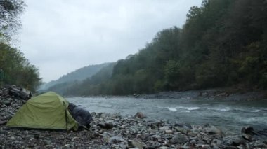 4 k. bir dağ nehir kıyısında bir turist çadır yakınındaki bir adam.