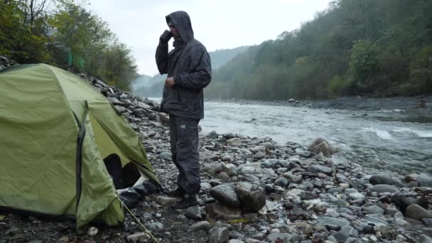 Bir turist çadır 4 k. görünümünden bir dağ nehir üzerinde. Kız adamla çay termosu şişe içine dökülen ve dağ nehir görünüyor. — Stok video