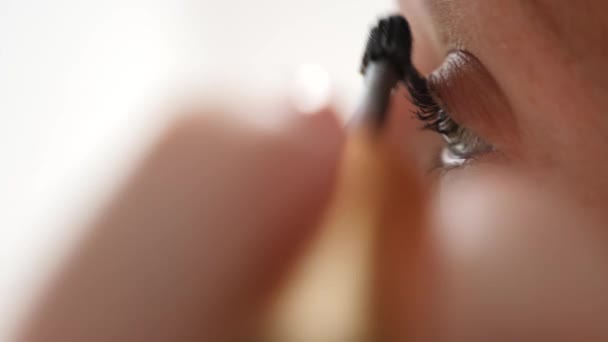 매크로 영상 속눈썹에 마스카라를 적용 하는 젊은 여자의 눈. 4 k, 슬로우 모션 — 비디오