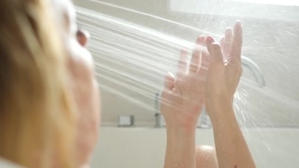 Vrouwelijke handen onder stromen van water uit de douche. bevochtigen van handen. 4k, slow-motion — Stockvideo