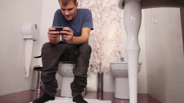 bir tuvalette otururken ve cep telefonunda arıyorum dostum. 4k, ağır çekim