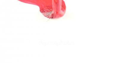 biri beyaz bir kağıda boya çizer. bir Püskül close-up. 4k, ağır çekim. seks kelimesini beyaz bir levha üzerinde kırmızı boya yazıyor