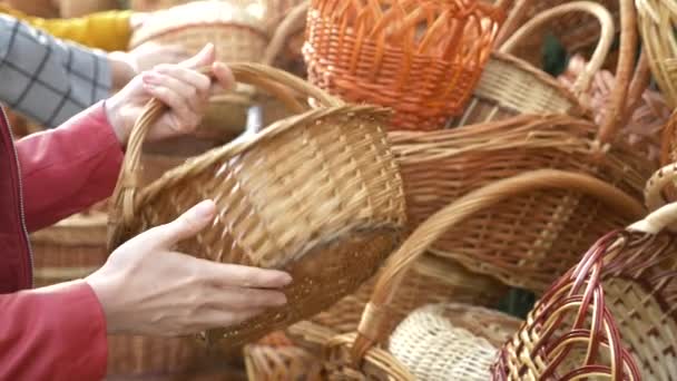 Una mujer elige una canasta de mimbre en una feria de artesanía popular. 4k, cámara lenta — Vídeos de Stock