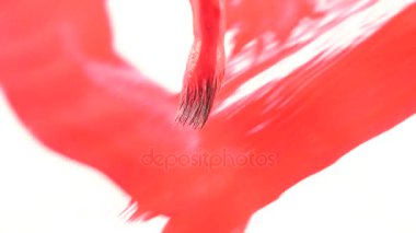 biri beyaz bir kağıda boya çizer. bir Püskül close-up. 4k, ağır çekim. bir kalp kırmızı boya ile çizmek