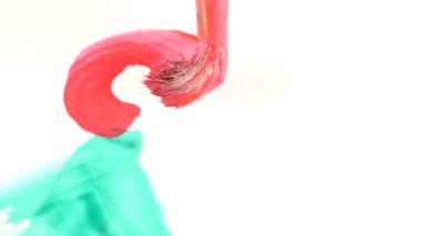 biri beyaz bir kağıda boya çizer. bir Püskül close-up. 4k, ağır çekim, bir Noel ağacı üzerinde beyaz bir levha çizer.