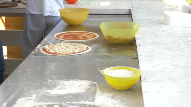 Шеф-повар готовит пиццу на открытой кухне ресторана. 4k, slow motion — стоковое видео