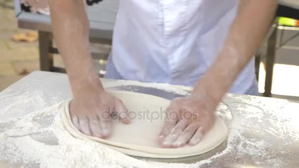 De chef-kok bereidt pizza in het restaurant van de open keuken van het restaurant. 4k, slow-motion — Stockvideo