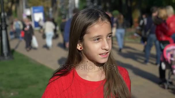 Una chica de pie en el fondo de una multitud anónima de personas caminando por la calle. 4k cámara lenta — Vídeos de Stock