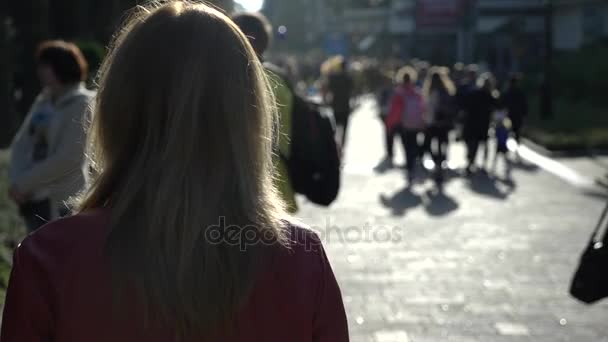 Mujer de pie en el fondo de una multitud anónima de personas caminando por la calle. 4k cámara lenta — Vídeo de stock