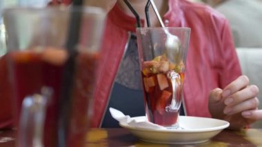 güzel kadın bir kafede dinlenme, sıcak mulled şarap içme ve onun smartphone arıyorum. 4k, arka plan bulanıklık.