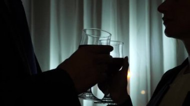 Genç kadın ve adam şarap duran bir ev pencere tarafından gece içme. Pencere panorama, gece ışık şehir görüntüsü. 4k