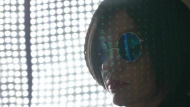 Sıcak esmer yuvarlak güneş gözlüğü, kameraya bakıyor. 4k, ağır çekim. yakın çekim