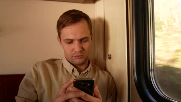 Ένα πρόσωπο που χρησιμοποιεί ένα smartphone σε ένα διαμέρισμα του μια επιβατική αμαξοστοιχία. 4k — Αρχείο Βίντεο