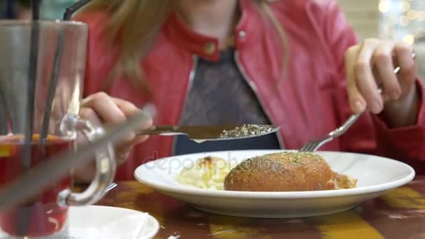 une femme dans un restaurant mangeant un rouleau de poulet avec des pommes de terre. 4k 