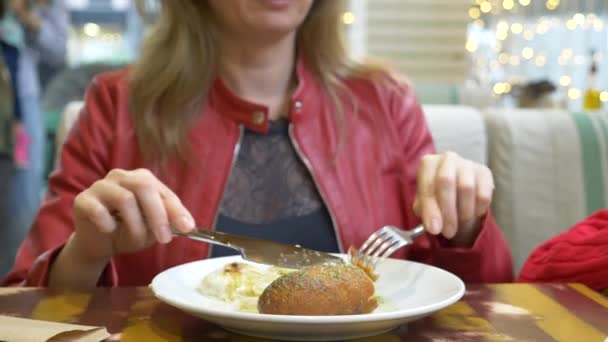Женщина в ресторане ест куриный рулет с картошкой. 4k — стоковое видео