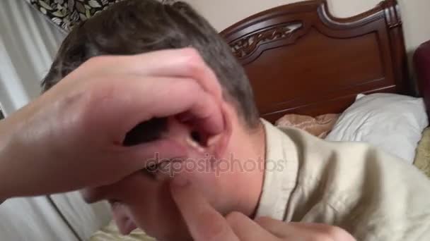 女性の手は、男の耳をクリーンアップします。綿棒で個人の衛生状態です。4 k、アクション — ストック動画