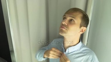 4k, bir adam giyim kendisi için bir giyim mağazasında seçer. Montaj odasında yeni elbiseler üzerinde çalışıyor