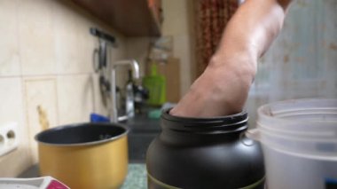 Ağır çekim. 4 k. genç adam bir protein shake evde yapma. Anonim