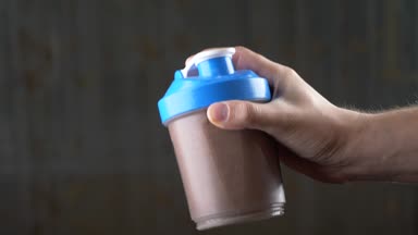 Ağır çekim. 4 k. genç adam bir protein shake evde yapma. Anonim