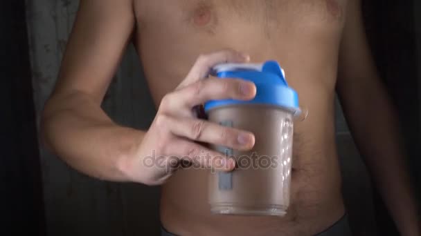Slow motion. 4 k. ung man att göra en proteinshake hemma. Anonymt — Stockvideo
