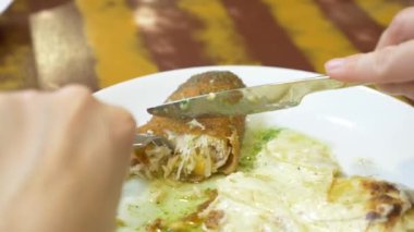 bir kadın bir restoranda bir tavuk rulo patates ile yemek. 4k