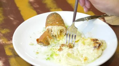 bir kadın bir restoranda bir tavuk rulo patates ile yemek. 4k