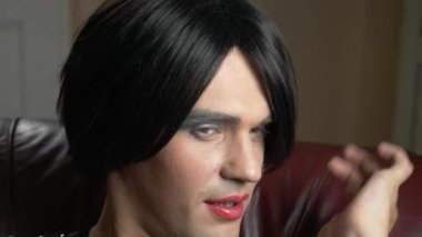 genç bir adam bir transeksüel suretinde seductively duman alacakaranlıkta bir puro sigara ve serbest kameraya. 4k, ağır çekim