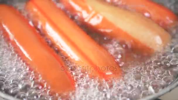 Le salsicce crude sono bollite in acqua su una stufa a gas. 4k, rallentatore — Video Stock
