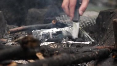 4k, ağır çekim. bir adam turist bir ızgara ormandaki ateş vuruyor.