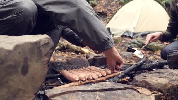 4k, Zeitlupe. Der Tourist kocht Würstchen auf einem Minigrill im Wald. Nahaufnahme — Stockvideo