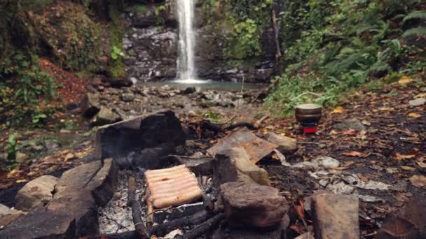 4k, slow-motion. de toerist is koken worst op een mini grill in het bos. — Stockvideo
