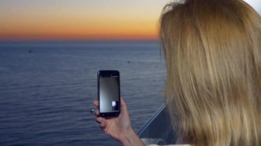 Çekici bir genç kadın, bir smartphone kullanarak balkon resort adlı bir kadın tarafından bir uygulama akıllı cep telefonu kullanarak video iletişimi iletişim kurar. 4k