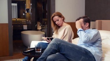 birkaç erkek ve kadın bir yatakta bir otel odasında oturup çalışma anlar, notlar bir defterde yapma tartışmak. 4k.