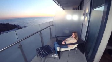 bir resort otel deniz manzaralı balkon bir dizüstü bilgisayar üzerinde çalışan 4 k. kadın. Uzak iş her yerde.
