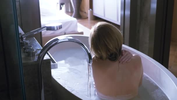 4K, uma mulher na casa de banho do hotel. de volta para a câmera — Vídeo de Stock
