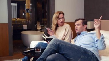 birkaç erkek ve kadın bir yatakta bir otel odasında oturup çalışma anlar, notlar bir defterde yapma tartışmak. 4k.