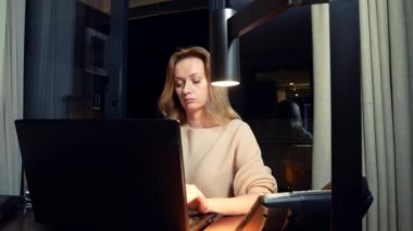 bir masada bir dizüstü bilgisayarda bir otel odasında geceleri çalışan kadın. 4k.