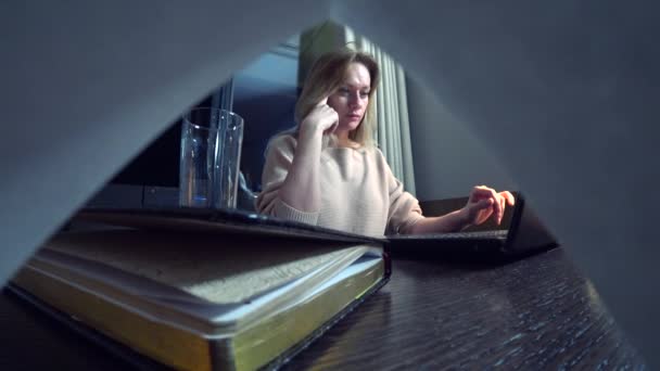 Mujer trabajando en un portátil en una mesa por la noche en una habitación de hotel. 4k . — Vídeos de Stock