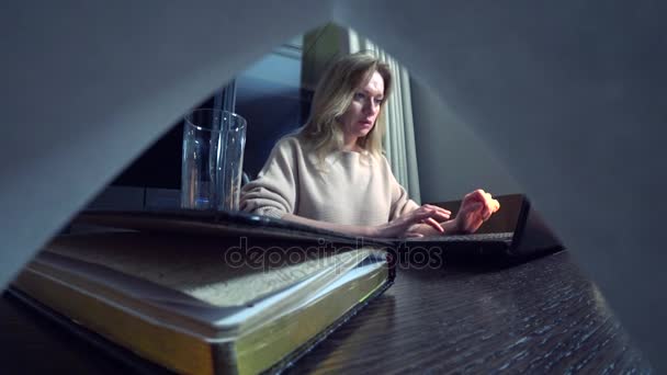 Frau arbeitet nachts an einem Laptop an einem Tisch in einem Hotelzimmer. 4k. — Stockvideo
