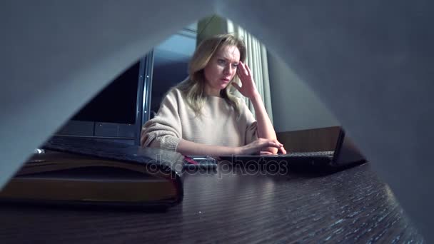 Kobieta pracuje na laptopie przy stole w nocy w pokoju hotelowym. 4k. — Wideo stockowe