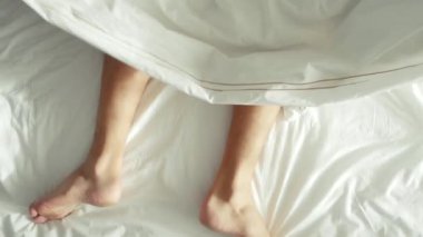 yatakta sevişen çift. erkek ve kadın bacakları görünümü, beyaz keten üst. seks, 4k