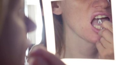 4k, yakın çekim. kadın banyoda ayna önünde diş ipi kullanır