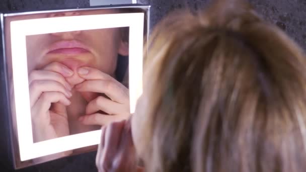 The woman squeezes acne, squeezes out pimples in front of the mirror. close-up, 4k — Stock Video