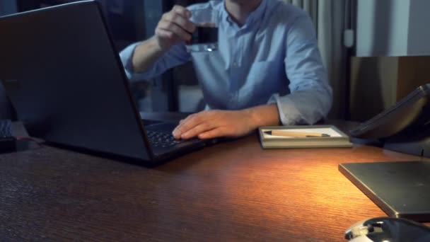 Hombre de negocios que bebe alcohol mientras trabaja con su computadora portátil en la noche, 4k — Vídeos de Stock