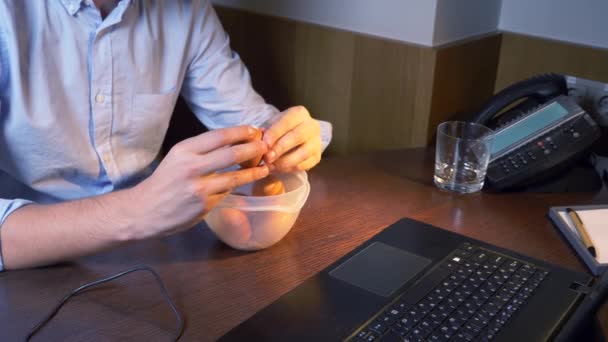A man eats boiled chicken eggs from a food container, working on a laptop, late at night, healthy food, a protein diet. 4k — Stock Video