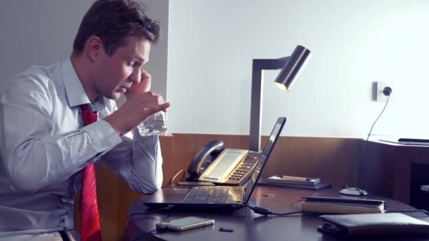 Zakenman, het drinken van alcohol tijdens het werken met zijn laptop's nachts, 4k — Stockvideo