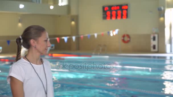 Dívka plaveckého trenéra, následuje cvičení plavec, otočí, podívá do kamery a úsměvy, 4k, pomalý pohyb — Stock video