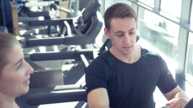 Genç Yetişkin kız onu kişisel antrenörü tarafından liderliğindeki simülatörleri bir egzersiz yapıyor. 4k, ağır çekim