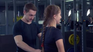 Genç Yetişkin kız onu kişisel antrenörü tarafından liderliğindeki simülatörleri bir egzersiz yapıyor. 4k, ağır çekim